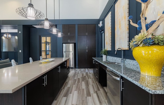 a large kitchen with black cabinets and a yellow vase