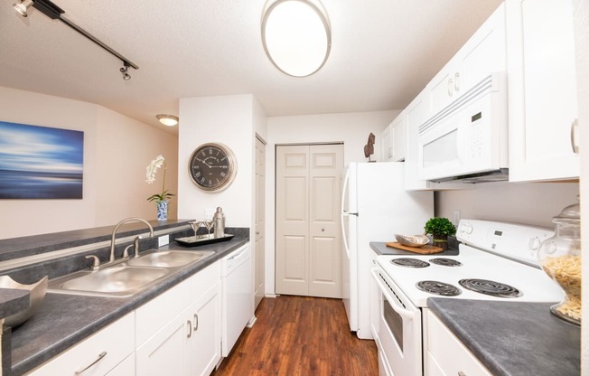 a kitchen with white cabinets and a white stove and a sink  at Butternut Ridge, North Olmsted