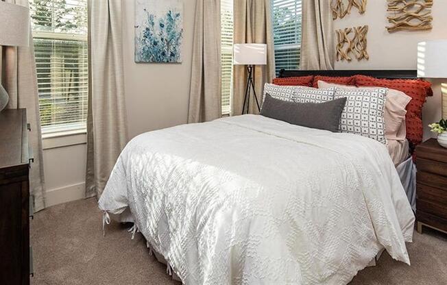 a bedroom with a bed and two windows at Promenade at Newnan Crossing, Newnan Georgia