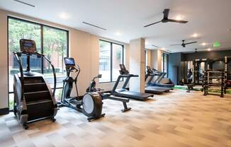 a gym with treadmills and other exercise equipment on a wooden floor