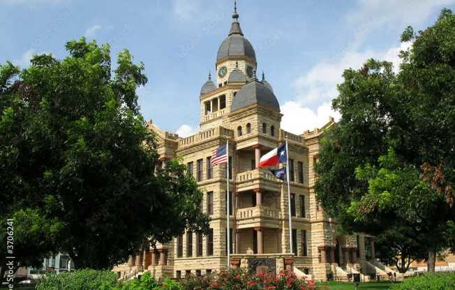a large building with a clock tower and a flag on the front