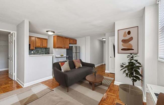 A living room with a grey couch and a brown abstract painting on the wall.