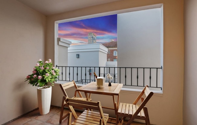 a balcony with a table and chairs and a large window