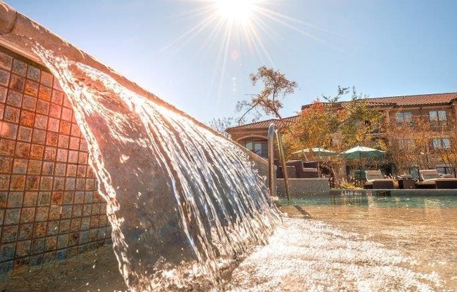 a water feature with the sun shining in the background