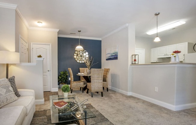 a living room and dining room with a table and chairs