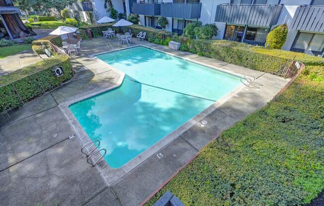 a swimming pool is shown in the backyard of an apartment building