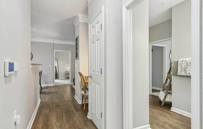A hallway with a wooden floor and white walls.