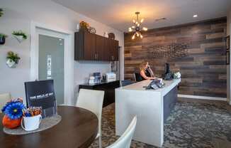 a woman sitting at a desk in a kitchen and dining room