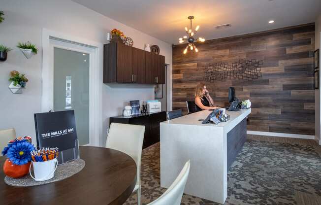 a woman sitting at a desk in a kitchen and dining room