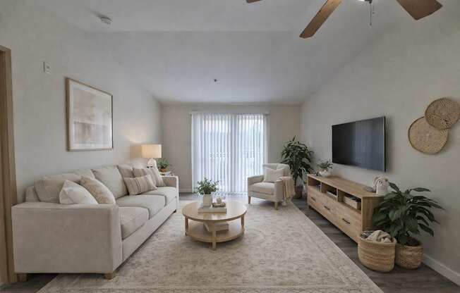 A living room with a beige sofa, a wooden coffee table, a flat-screen TV, and a ceiling fan.