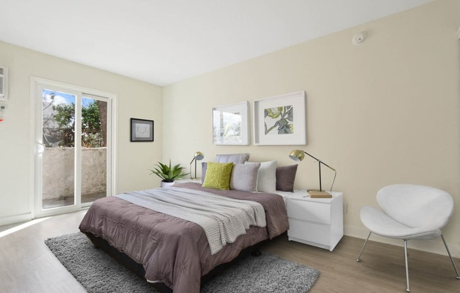 Bedroom with wood style floors, private balcony or patio with sliding glass door on the left