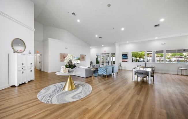 a living room with white walls and wooden floors and a table with a mirror