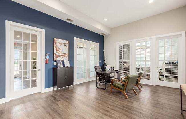 A room with a desk and chairs in it.