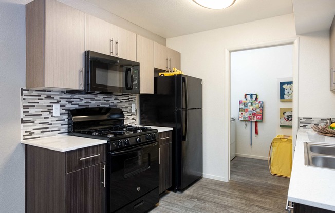 a kitchen with black appliances and a black refrigerator