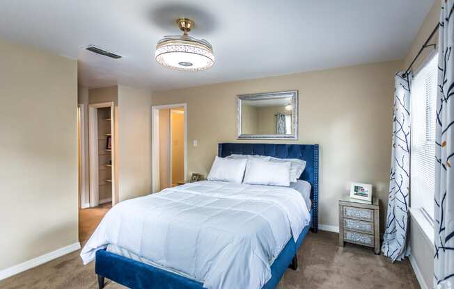 a bedroom with a blue and white bed and a closet