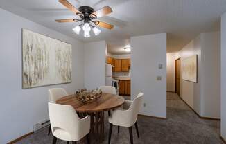 a dining room with a table and chairs and a ceiling fan. Fargo, ND Crescent Park Apartments