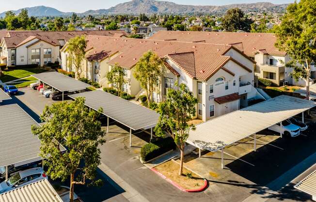 A large group of houses with a parking lot in front.