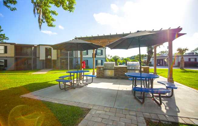 a patio with picnic tables and umbrellas