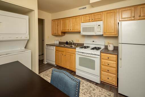 A kitchen with wooden cabinets and white appliances.