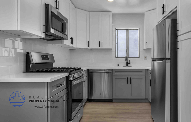 a kitchen with white cabinets and stainless steel appliances