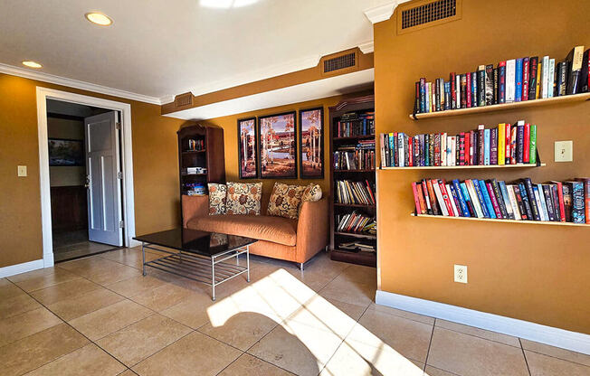 a library with a couch and a shelf of books
