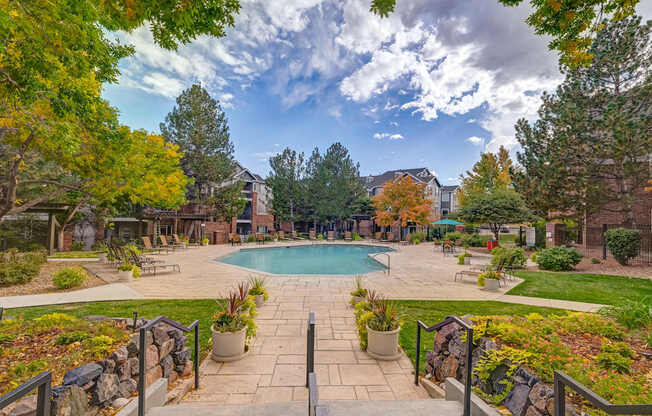 a view of a swimming pool with trees and a building in the background