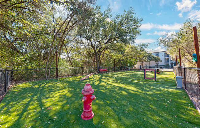 A red fire hydrant sits in the middle of a green grassy area.