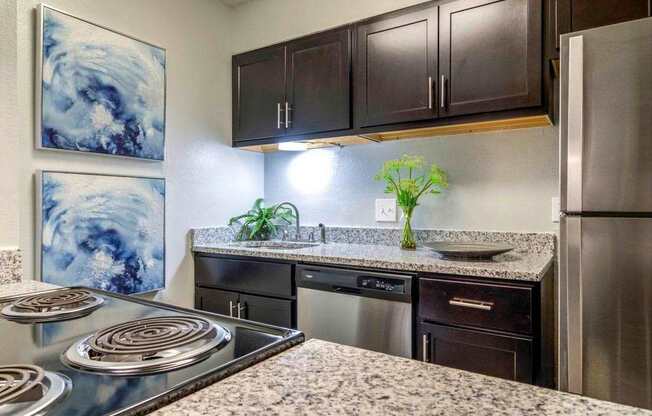 A kitchen with a stove top oven and a refrigerator.