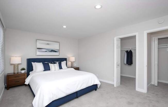 A bedroom with a large bed and a painting on the wall.