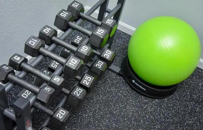 a pile of weights next to a green ball