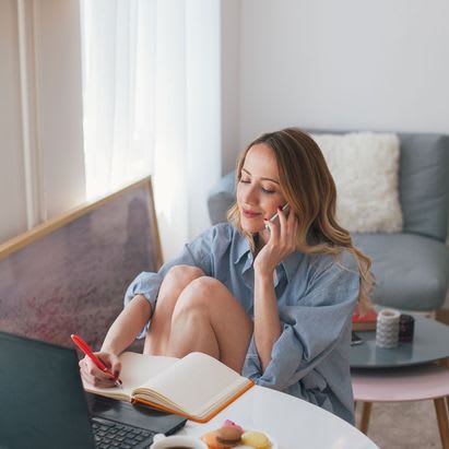 Woman Noting Down In Notebook While On Phone at The Palms on Main, Columbia, 29201