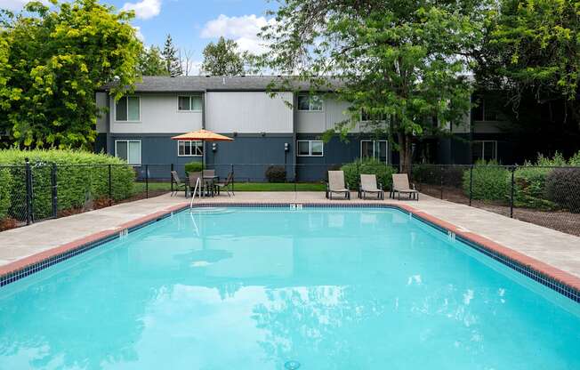 A swimming pool surrounded by a fence and trees.