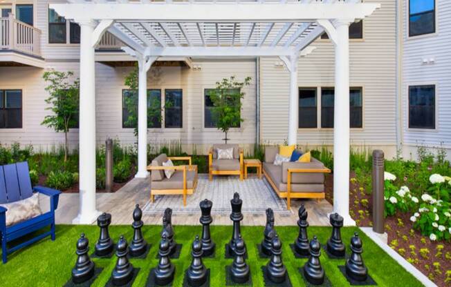 A large chess set is set up on a lawn.