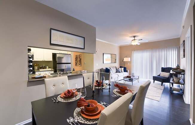A modern dining room with a black table set for two.