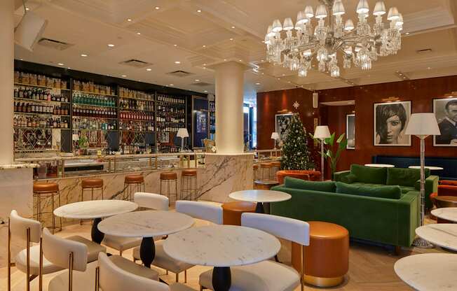 A well-lit, modern cafe with a variety of seating options and a large chandelier.