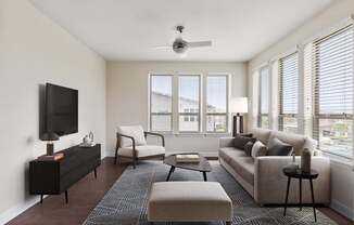 A living room with a television, a couch, a chair, a coffee table, and a rug.