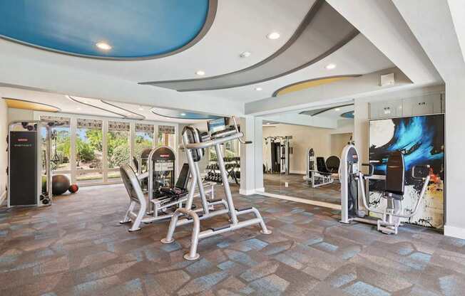 A gym with a variety of equipment including a treadmill, weights, and a television.