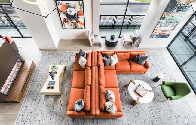 Expansive resident lounge with floor-to-ceiling windows, bold design, and inviting spaces to gather.