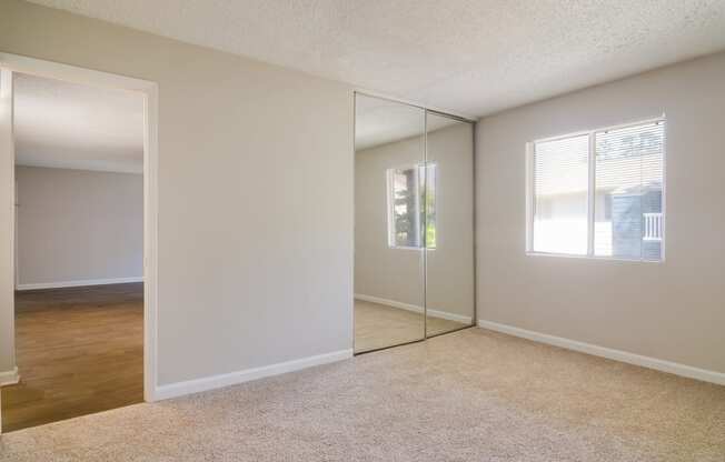 an empty bedroom with a large mirror