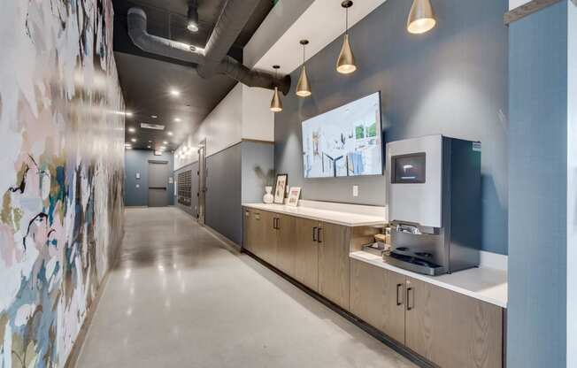a hallway with a coffee machine and a wall with a painting