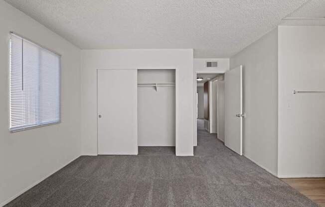 A long hallway with white doors and a carpeted floor.