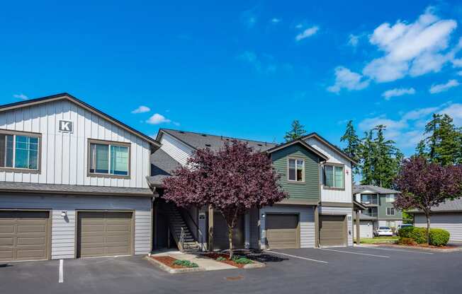 a house with two garages and a tree in front of it