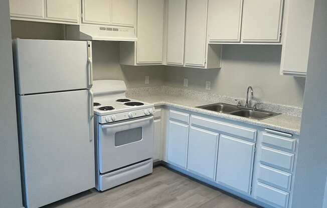 A kitchen with white appliances and cabinets.