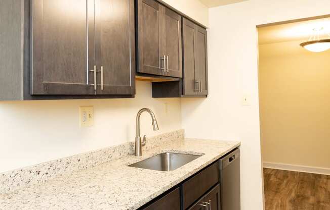 a kitchen with dark wood cabinets and a granite counter top