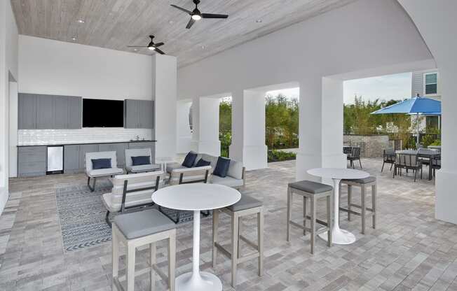 a rendering of a patio area with tables and chairs and a kitchen in the background