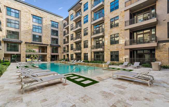 A large building with a pool in front of it.