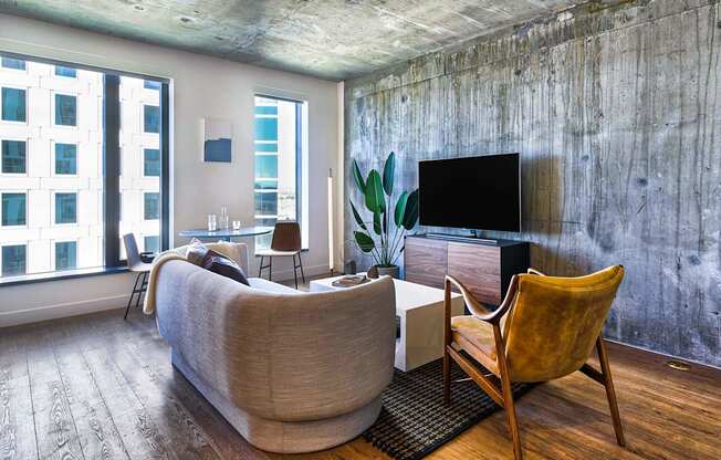 A living room with a couch, chair, and television.