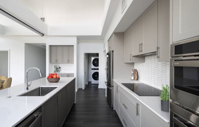 a large kitchen with white counter tops and black appliances  at The Belden Stratford, Chicago, 60614