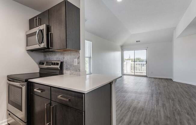 A modern kitchen with dark wood cabinets and stainless steel appliances.