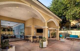 a patio with tables and chairs and a flat screen tv